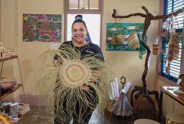 Woman holding Aboriginal weaving