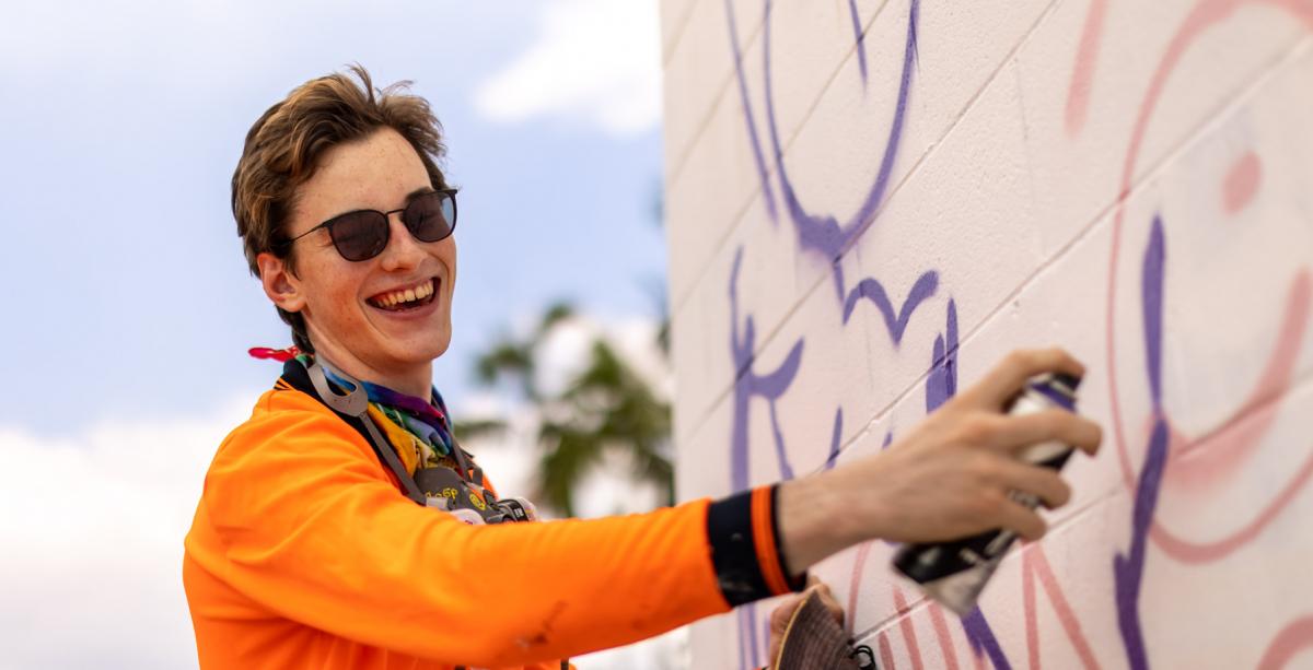 Caleb spray painting a wall in Wulagi