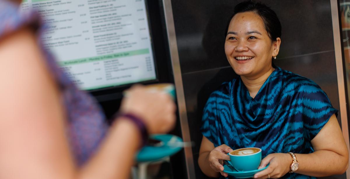 Woman holding a coffee in blue mug