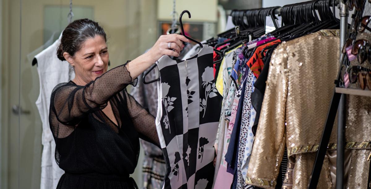 Michelle holding up a garment inside her store