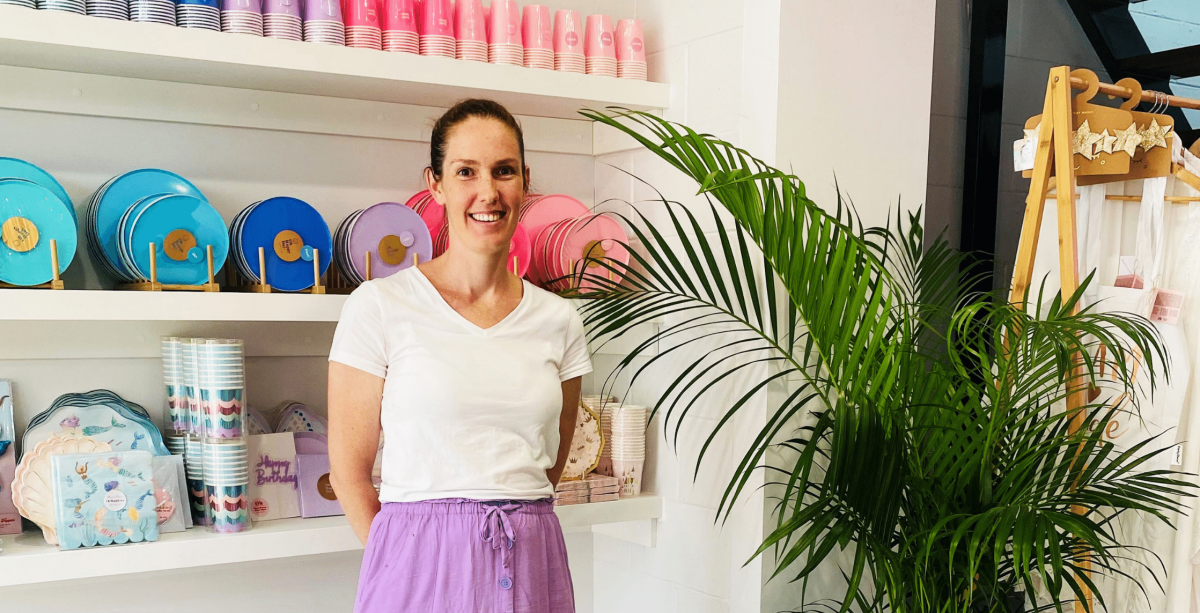 Owner Marissa standing in front of party plates and cups